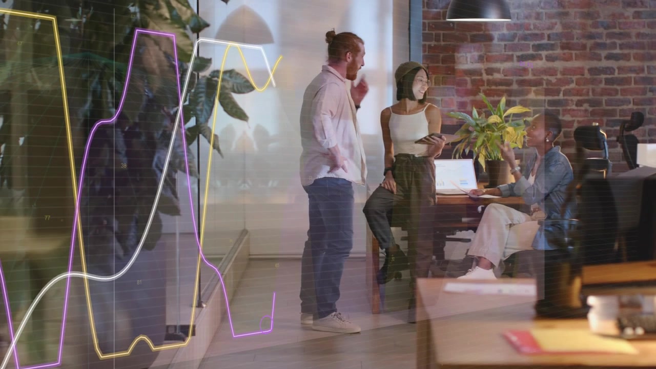 Woman tapping tablet, coworker pointing at laptop while team planning business, neon lines in glass