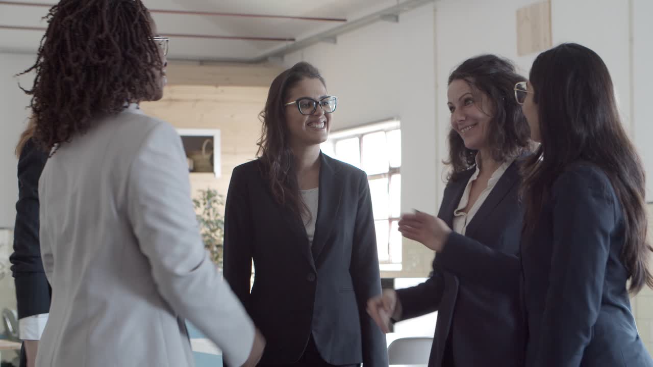 Mulheres de negócios felizes a apertar as mãos.