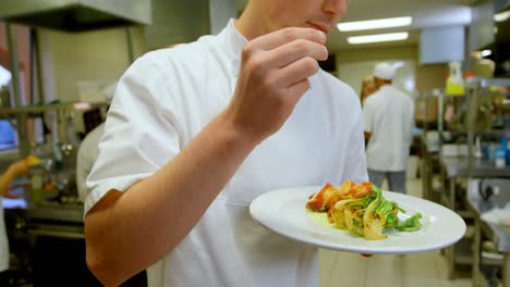 chef rociando sal en el plato en la cocina 4k