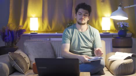 estudiante masculino tratando de terminar su tarea por la noche.