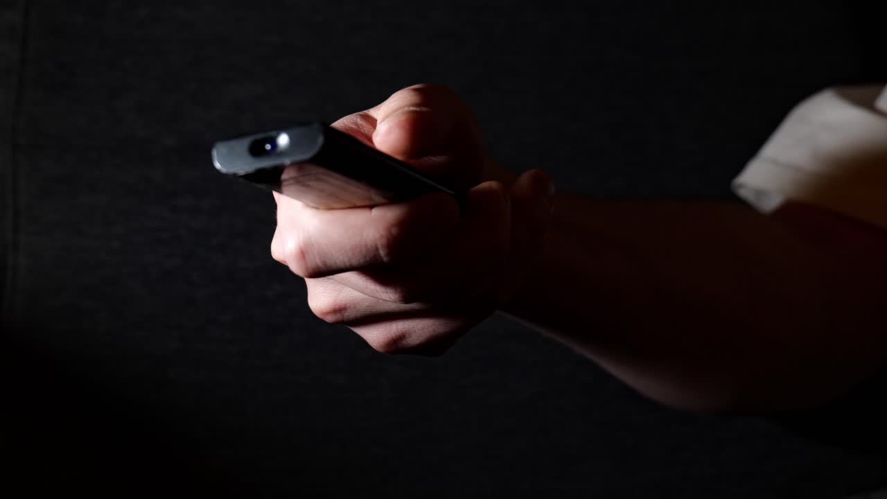 Close-Up of Man Holding Remote Control Changing TV Channels