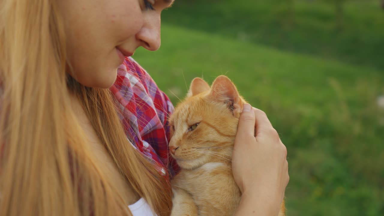 Young Caucasian woman gently holding and cuddling an orange cat in warm cinematic lighting, showing love, affection, and the bond between humans and pets in a cozy, intimate atmosphere