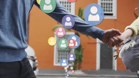 animation of social media icons floating over caucasian couple walking and holding hands