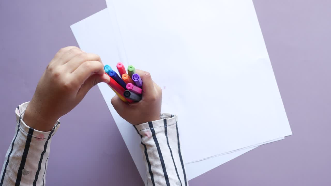 Child girl holding many  pencils