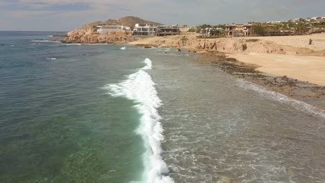 olas llegando a la playa en cabo san lucas en un dron todavía disparado