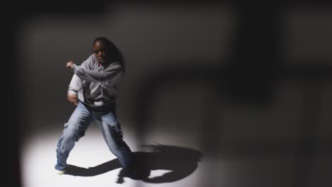 Full-Length-Studio-Portrait-Shot-Of-Young-Woman-Dancer-Dancing-In-Spotlight-With-Shadows-In-Foreground