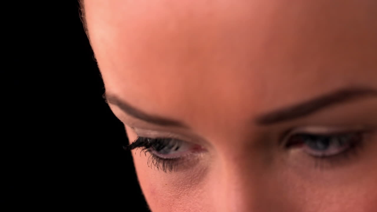 Close up of womans eyes on black background