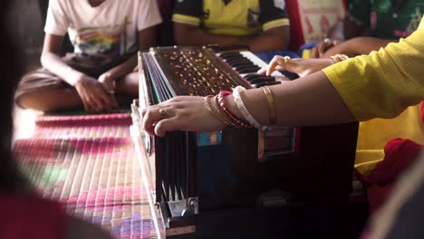 unrecognizable music teacher teaching students music with harmonium, slow track forward shot