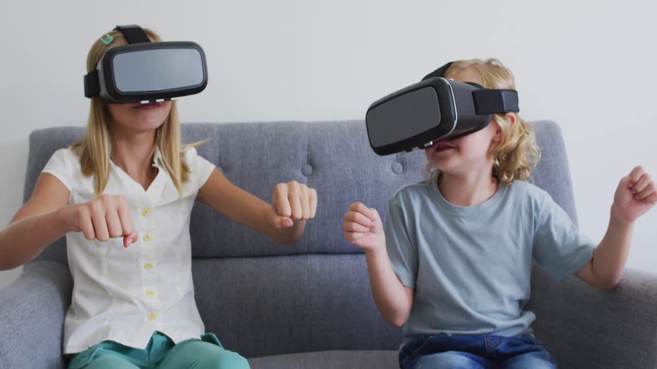 hermano y hermana caucásicos gesticulando mientras usan auriculares vr sentados en el sofá en casa