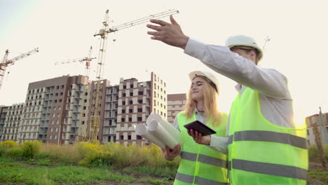 El-Gerente-De-Construcción-Y-El-Ingeniero-Caminan-Trabajando-En-El-Sitio-De-Construcción-Usando-Tabletas-E-Impresiones.