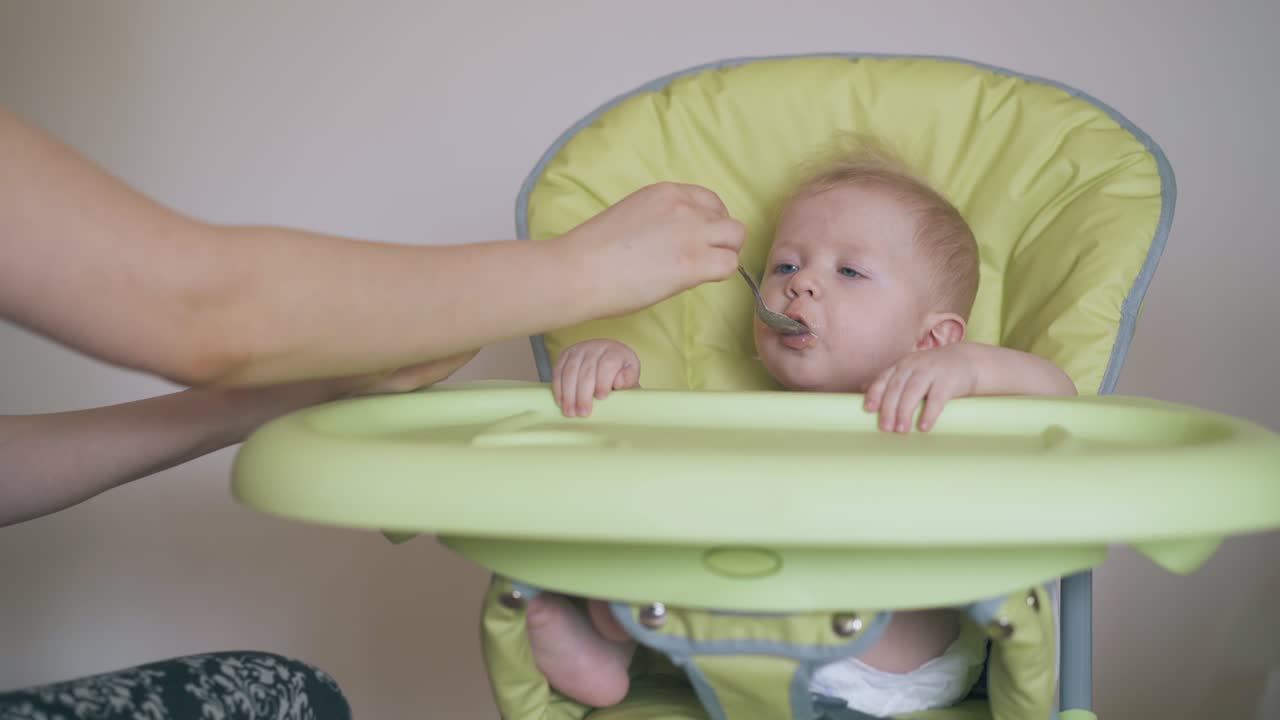 엄마 는 어린 아들이 높은 의자 에 앉아 건강 한 가루 를 먹게 한다