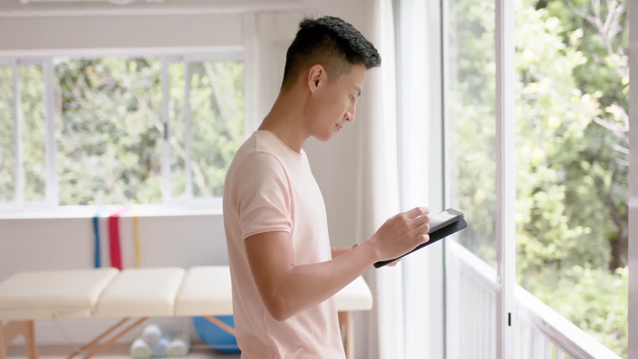 스튜디오에서 태블릿을 사용하는 행복한 두 인종 남성 물리 치료사의 초상화, 슬로우 모션