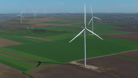 wind turbines in a vast green landscape on a sunny day, captured from above