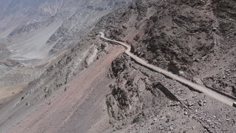 Aerial-View,-Dangerous-Hillside-Dirt-Road,-Rocky-Landscape-of-Northern-Pakistan,-Drone-Shot