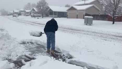 shoveling snow during heavy snow storm in northern colorado greeley 2021