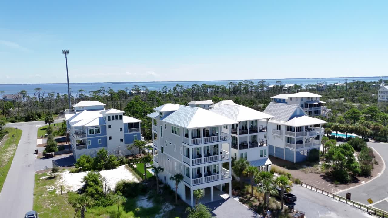 Panorama drone view of white coastal houses near green forested area and sandy beach, Cape San Blas, Gulf County, Florida, USA