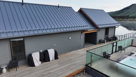 Casa-De-Botes-De-Lujo-Moderna-En-Un-Pequeño-Lago-En-Colorado-Temprano-En-La-Mañana-Con-Vapor-Saliendo-Del-Agua-Pasando-Por-Un-Camión-Aéreo-Con-Bañera-De-Hidromasaje