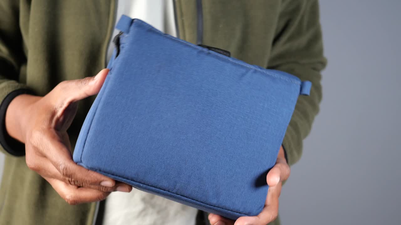 Person Holding a Dark Blue Fabric Pouch