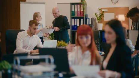 Kollegen-Diskutieren-über-Dokument-Im-Büro.