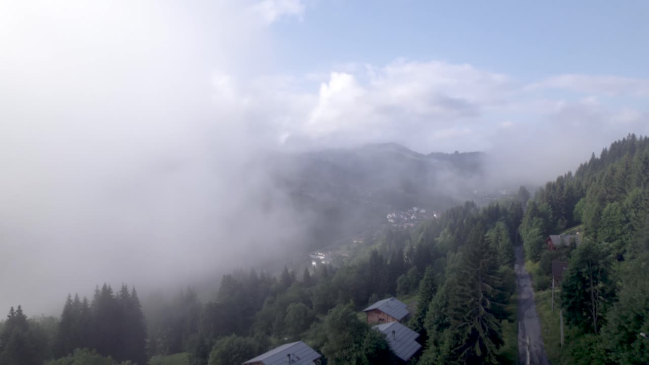 산비탈과 푸른 초원, 소나무가 계곡의 절반을 가리는 구름으로 나누어져 있는 캐빈 공중 위로 솟아오릅니다.