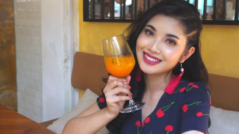 woman enjoying a fruit drink in a cafe
