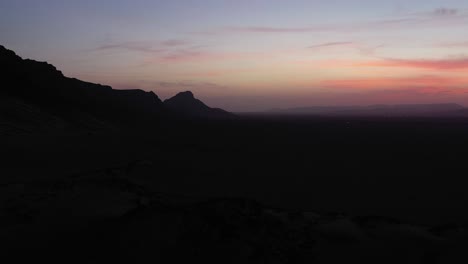 silhouette of mountain in desert at sunset with multicolored sky, morocco