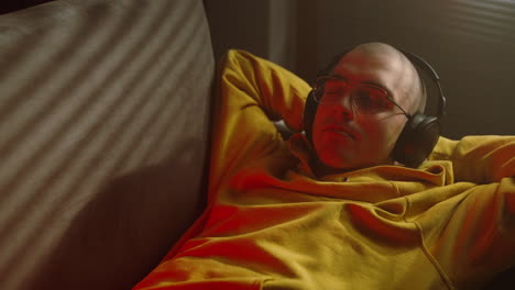 hombre relajándose en un sofá con auriculares