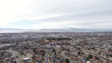 Avance-Aéreo-Sobre-La-Ciudad-De-Provo-En-Utah-Con-Montañas-Cubiertas-De-Nieve-En-Segundo-Plano.