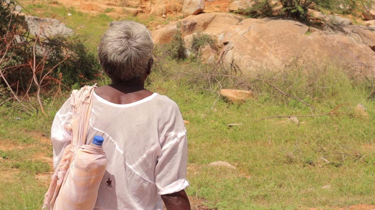 덥고 화창한 날 인도의 산을 보고 식히고 담배를 피울 수 있는 천으로 덮인 늙은 부족 목자나 양치기 남자