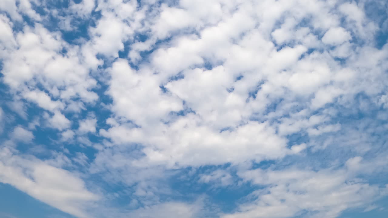White beautiful cirrus-cumulus cloudscape spreading along the horizon. Summer skies with clouds from low angle perspective. Timelapse.