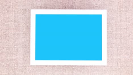 marco con pantalla azul y ramas de pino con adornos blancos rosados. detener el movimiento