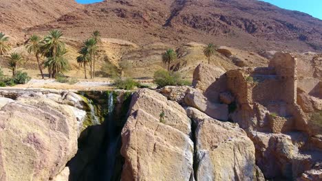 drone shot of a waterfall between desert mountains in bousaada algeria