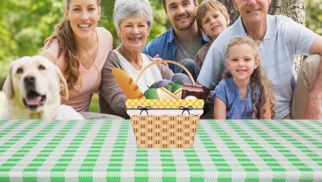animation of picnic basket on gingham tablecloth and happy caucasian multi generation family in park