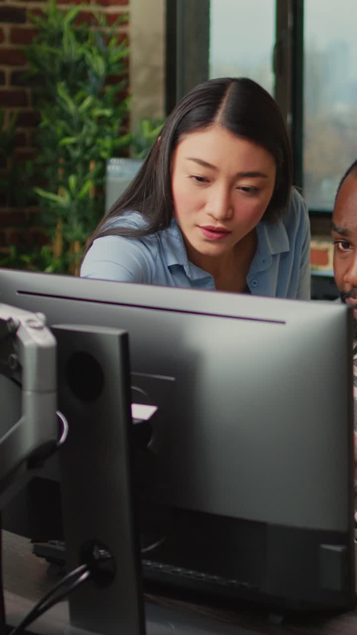 Vertical video: Multiethnic team of employees developing 3d content on professional software