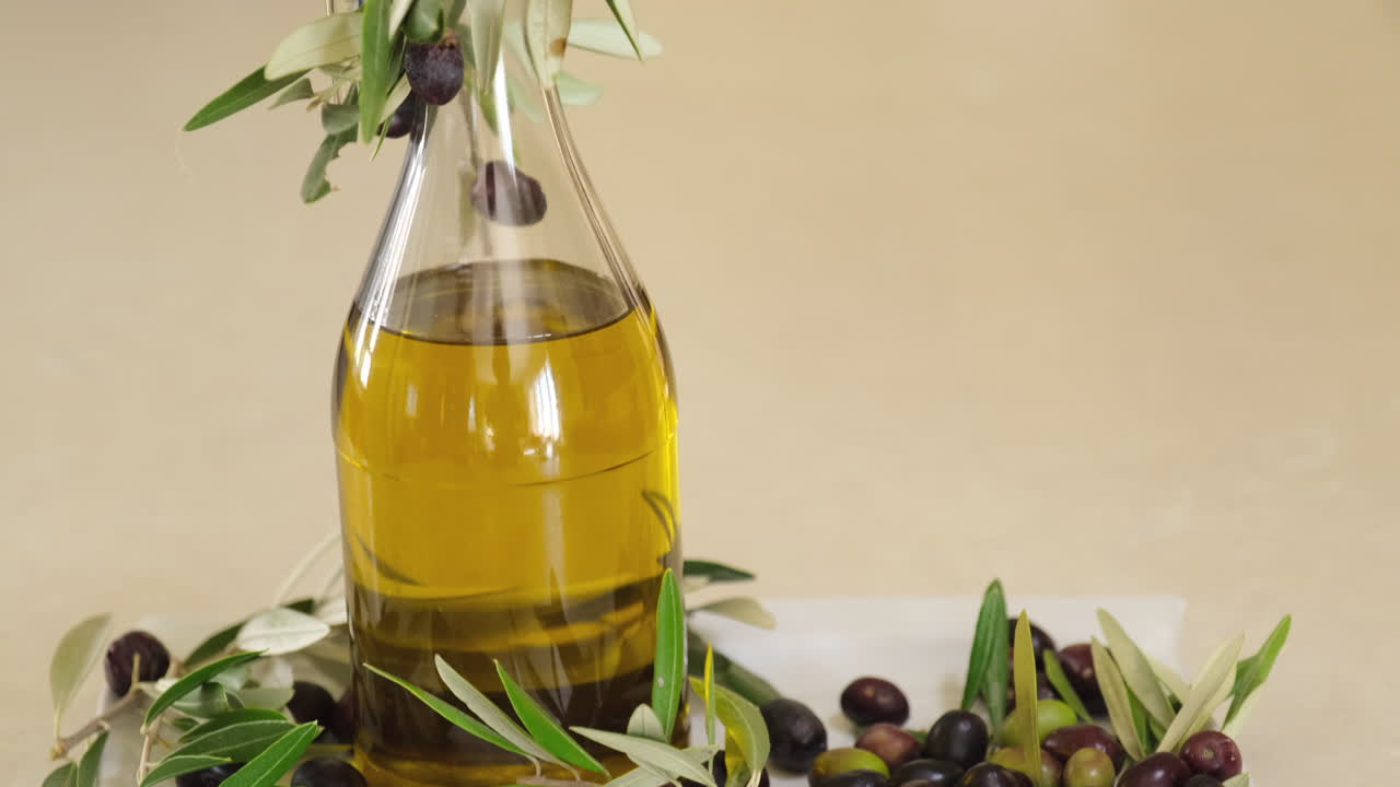 병에 든 엑스트라 버진 오일, 백그라운드에서 빨간색과 검은색 올리브