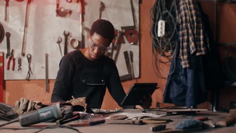trabajador metalúrgico en un taller usando una tableta