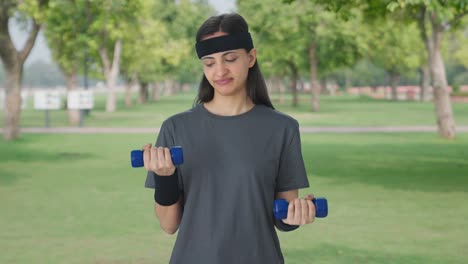 sad indian girl lifting dumbbells