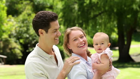 happy parents with their baby girl in the park