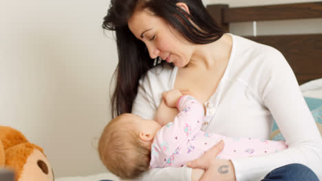 Mother-breast-feeding-her-baby-on-bed