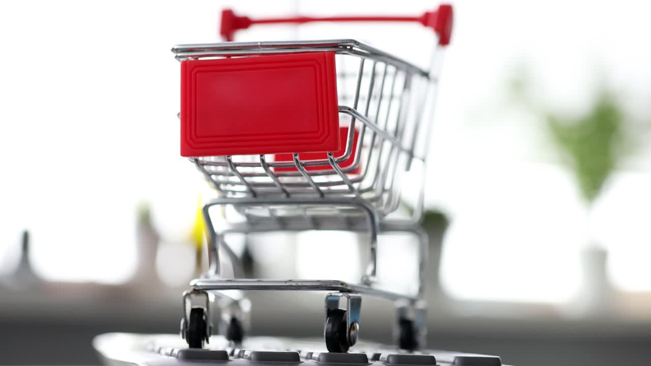 Toy metal grocery cart standing on keyboard 4k movie
