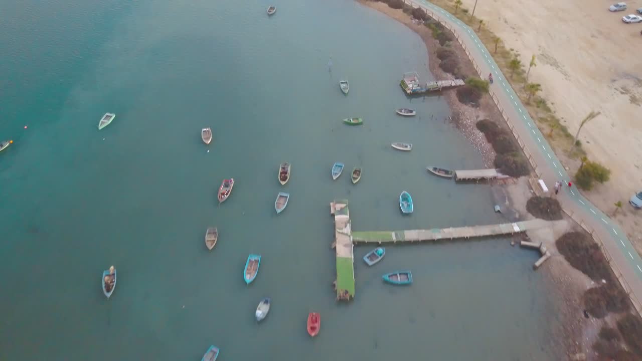 Ripresa aerea dall'alto di piccole barche da pesca in legno sulla costa di Barbate a Cadice, Spagna.