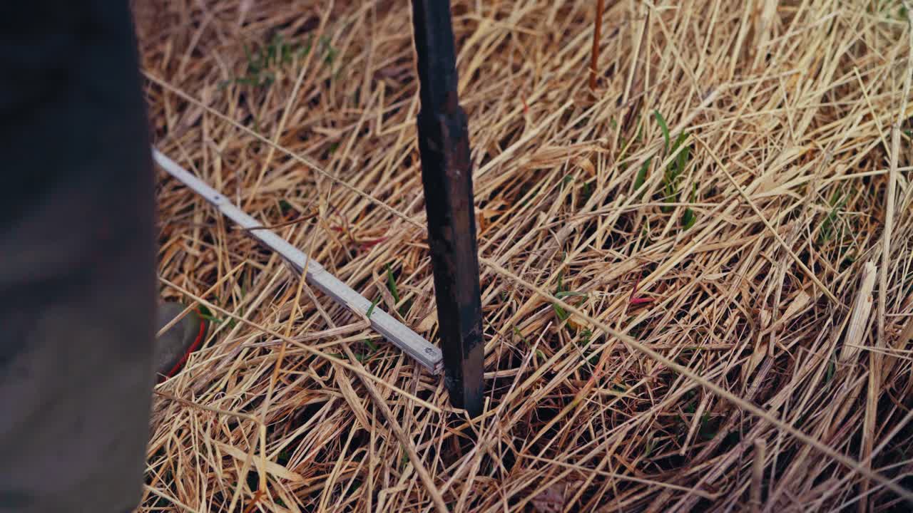 Man Digging Holes For Building Traditional Fence - Close Up