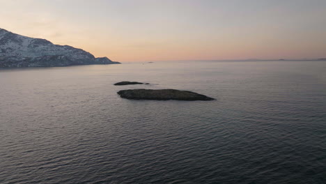 Drone-Aéreo-Orbita-Pequeña-Isla-Rocosa,-Tromvik-Kvaloya-Puesta-De-Sol-Del-Norte-De-Noruega