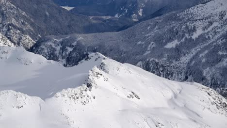 Sunny-Mountain-Valley-Winter-Landscape-and-Snow-Covered-Peaks-AERIAL