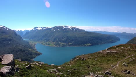 panoramic timelapse showing olden and innvikfjord seen from mountain hoven and loen skylift restaurant - summer static timelapse with moving boats and clouds in background