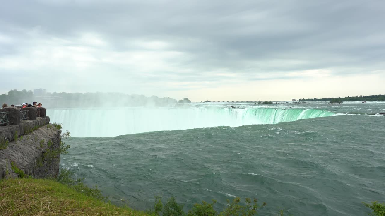 Krajobrazowy widok Wodospadu Niagara z wodą spływającą w dół, tworzącą parę, w pochmurny dzień
