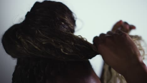 close up studio beauty shot of woman putting up hair