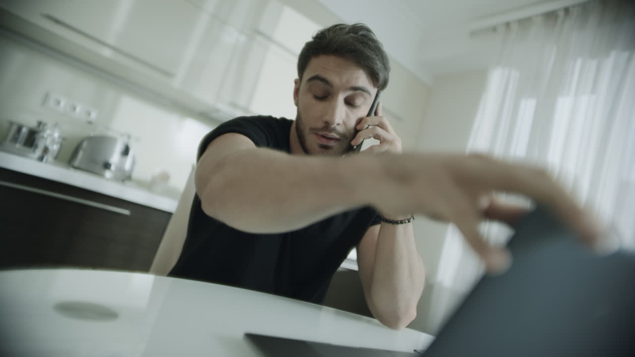 Angry man talking mobile phone at home. Frustrated entrepreneur