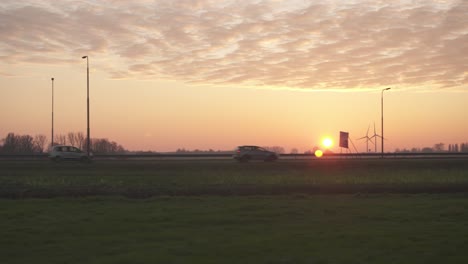 Aerial:-busy-highway-road-at-sunset-through-Dutch-countryside-scenery