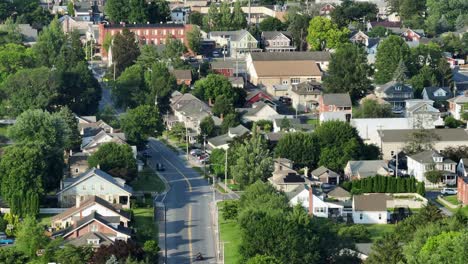 peaceful sunrise morning in small american town with cars on street. historic buildings and houses of neighborhood. summer season in pennsylvania. aerial wide shot
